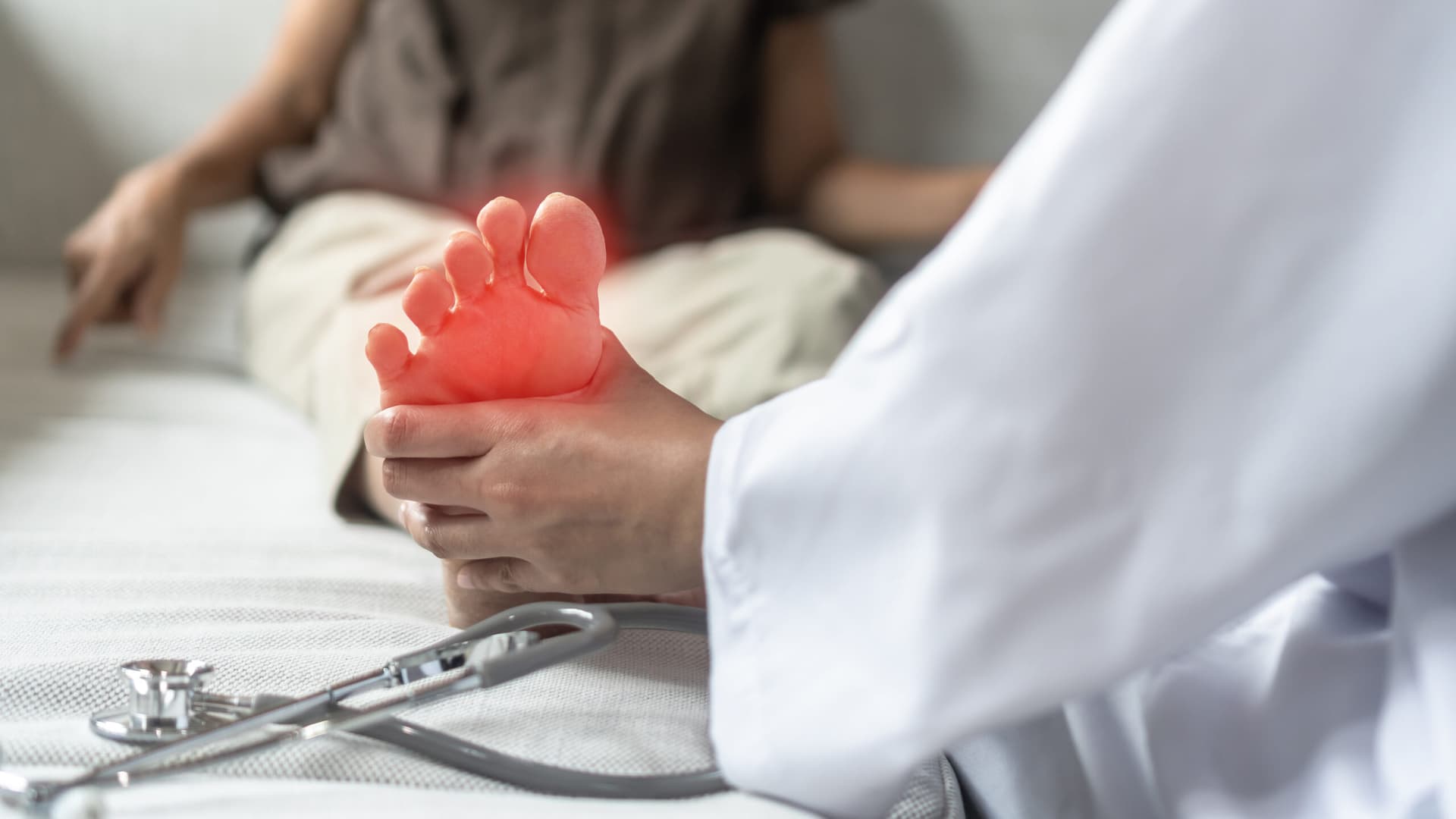 Arzt hält schmerzenden Fuß einer Patientin mit Polyneuropathie